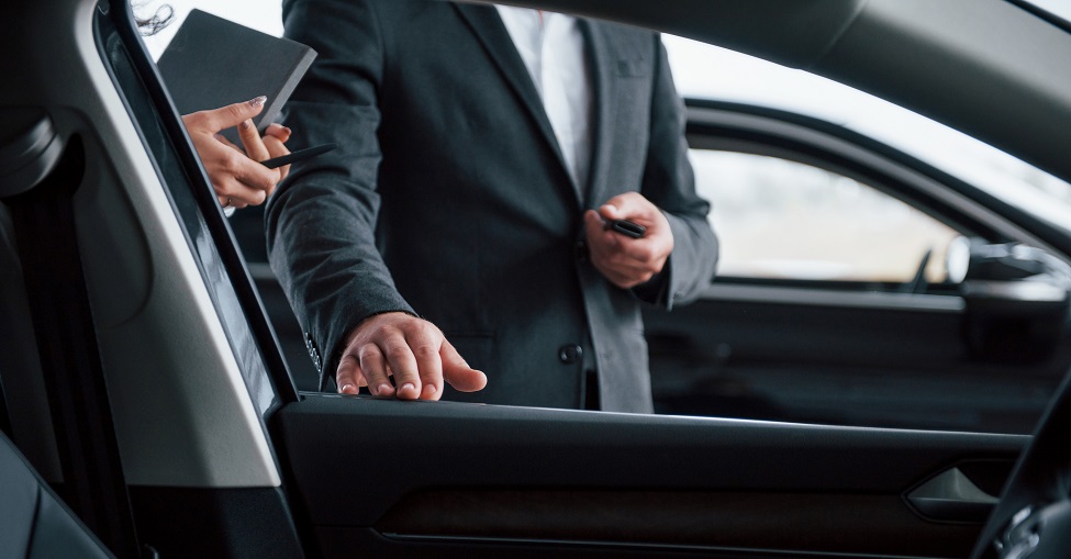 photo from the inside of vehicle. female customer and modern stylish bearded businessman in the automobile saloon